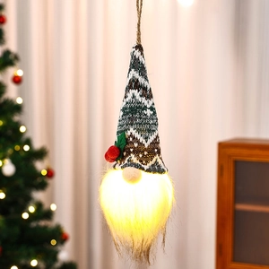 Detail eines leuchtenden Weihnachtswichtels mit Strickmütze und warmem LED-Licht