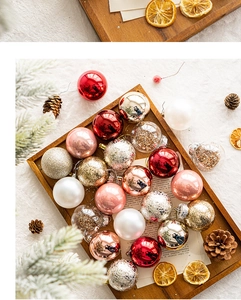 Flat lay of colorful Christmas ball ornaments on wood tray with pine cones and pine branches