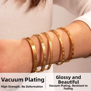 Close-up of gold-plated bracelets featuring star and heart charms with pavé crystals