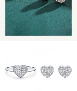 Detail of S925 sterling silver heart jewelry set with pavé diamonds on green velvet