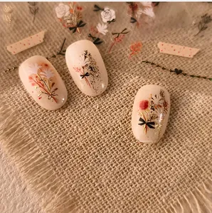 Detail of M-631 3D gold nail stickers featuring floral patterns and black bows on nails