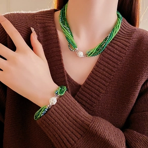 Détail de l'ensemble collier et bracelet multi-rangs en perles de cristal vert émeraude