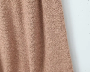 Detailed macro view of the premium brown knit fabric texture and vertical ribbing patterns