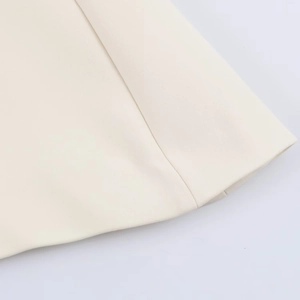 Close-up detail of high-quality stitching and creamy off-white fabric on a puff sleeve top