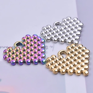 Close-up of heart-shaped stainless steel pendants in gold, silver, and rainbow finishes