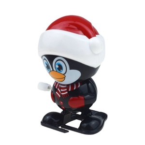 Wind-up Christmas penguin toy with red Santa hat and striped scarf on white background