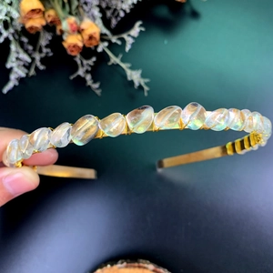 Macro detail of handmade gold crown headband with iridescent crystals and wire wrapping
