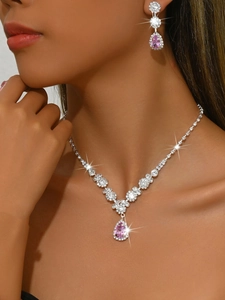 Macro shot of silver bridal necklace and earrings set with pink teardrop crystal gems