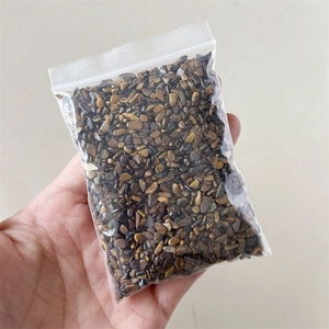 Close-up of small polished brown and yellow natural crystal stones in a clear zip bag
