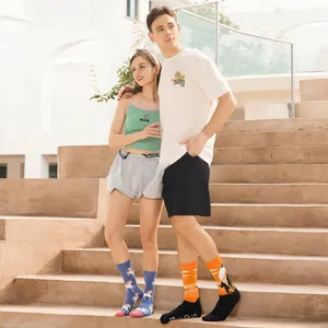 Detailed view of mid-calf socks featuring blue unicorn and orange sunset silhouette patterns