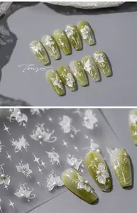 Detail view of 5D embossed olive green nail stickers with white flowers and pearls