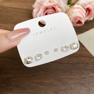 Close-up of cat-themed earring set featuring Hello Kitty designs and pink cubic zirconia
