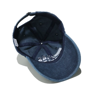Detailed interior of navy washed cotton baseball cap with 100% cotton label and metal strap