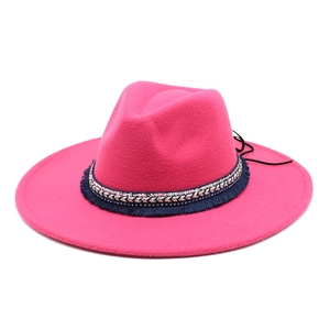 Close-up of bright fuchsia wool fedora with ethnic sequined band and blue fringe details