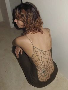 Detail view of the spider web crochet back design on an olive green backless dress