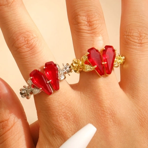 Close-up of gothic rose vine rings with coffin-shaped red crystals on model hand