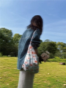 French country style floral cotton tote bag shown in a sunny outdoor meadow scene