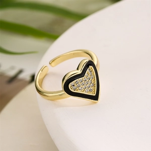 Macro shot of gold heart ring with black enamel and sparkling cubic zirconia stones