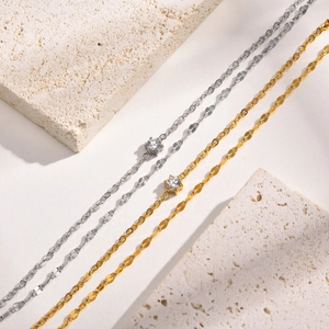 Détail de bracelets double épaisseur or et argent avec zircon étincelant serti en étoile
