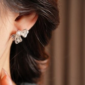 Vue macro de boucles d'oreilles nœud en argent avec zircons brillants et design creux