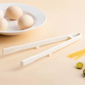 Beige heat-resistant silicone food tongs for cooking pasta and steak in the kitchen