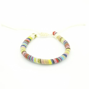 Close-up of handmade bohemian woven surfing bracelet with colorful striped patterns