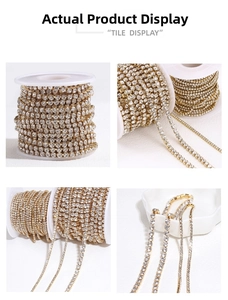 Detailed view of gold plated rhinestone claw chain on a white textured background