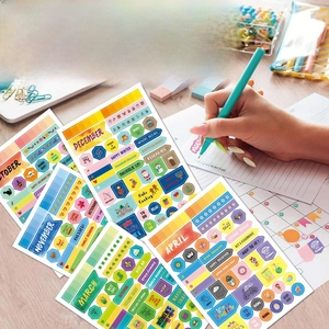 Detailed view of colorful monthly planner stickers with handwritten notes on a desk