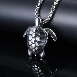 Polished silver turtle pendant with textured detail on a steel box chain necklace