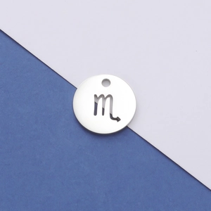 Detailed macro view of silver stainless steel Scorpio zodiac pendant on blue background