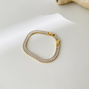 Detail of 18k gold plated tennis bracelet with baguette-cut zircons and secure clasp