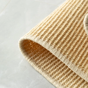 Detailed macro view of natural sisal carpet showing woven texture and durable hemmed edges