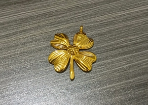 Detailed macro view of a gold-plated stainless steel four-leaf clover flower pendant