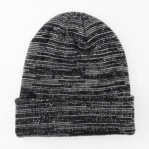 Detailed knit texture of a black and white marled winter beanie with ribbed cuff