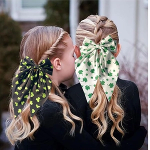 Elegant bow hair clip with clover print worn by a model in natural outdoor light