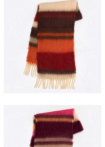 Detail of soft striped cashmere-like scarves featuring elegant tassels and colorful fringe