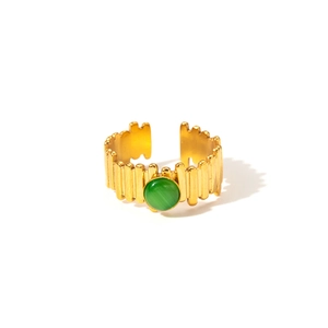 Detail of 18K gold-plated ring with green round natural stone and ribbed texture