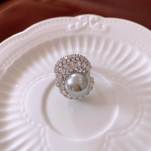 Detailed macro view of silver ring featuring large grey pearl and pavé cubic zirconia stars