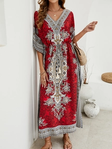 Detail of bohemian red floral maxi dress with V-neck and drawstring waist in resort setting