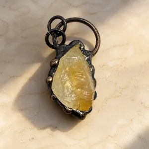 Dettaglio del ciondolo in citrino naturale grezzo con castone in bronzo vintage