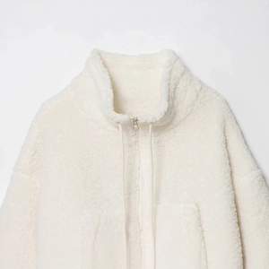 Women's fluffy white sherpa fleece jacket with a high stand collar and metal zipper detail