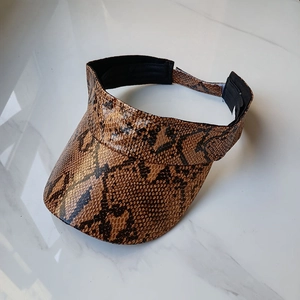 Detail of brown snakeskin faux leather visor with adjustable strap and textured finish