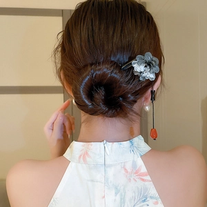 Detail of grey translucent flower hairpin with black and orange beads on wood stick