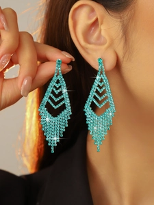 Model wearing elegant peacock green rhinestone tassel earrings with geometric diamond design
