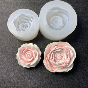 Macro view of 3D rose and peony flower silicone molds with finished plaster craft pieces