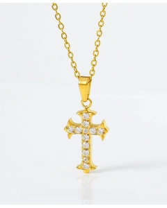 Detail of gold cross pendant with micro-paved cubic zirconia crystals on white background