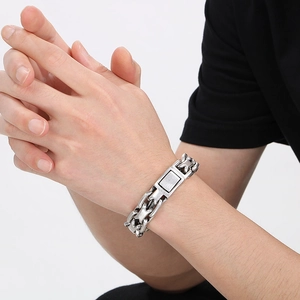 Detail view of a vintage silver stainless steel chain bracelet worn on a male wrist