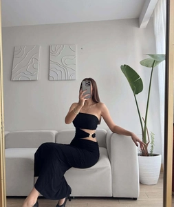 Detail of black cut-out waist maxi dress featuring a decorative gold metal ring connector