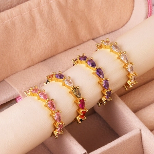 Macro detail of pear-cut zircon rings in gold plating with pink and purple stones