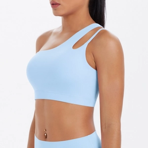 Detail of light blue one-shoulder sports bra with cutout design and high-waist yoga leggings